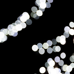 Abstract bokeh of white city lights on black background. defocused and blurred many round light