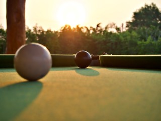 The morning light that shine over the white and black billiard ball on the pool table