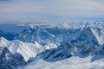 Fototapeta na wymiar Verschneite Berggipfel um die Zugspitze mit bluen Himmel und Wolken