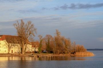 frauenchiemsee at sunset with blue sky clouds and trees