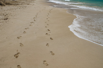 Fußspuren im Sand mit Wellen