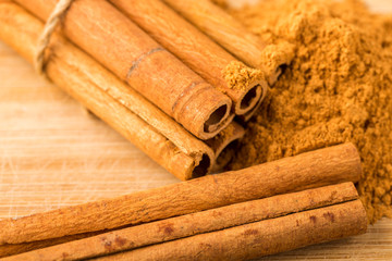 Cinnamon sticks and powder on wooden table