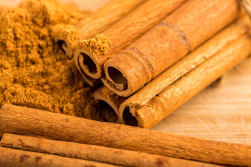 Cinnamon sticks and powder on wooden table