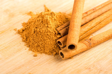 Cinnamon sticks and powder on wooden table