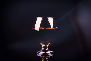 glass with cognac on a black background