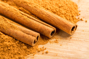 Cinnamon sticks and powder on wooden table