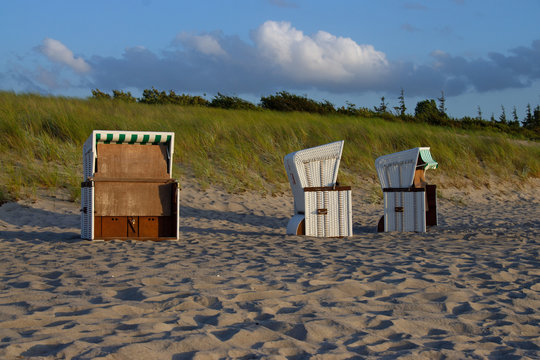 Drei Strandk&ouml;rbe am Sandstrand vorm Deich