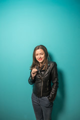 Fashioned girl in leather jacket in dark glasses in pink and blue  neon lights background. 