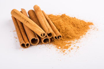Cinnamon sticks and powder on white background