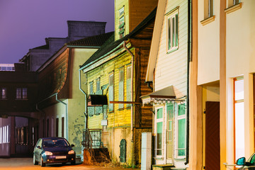 Fototapeta premium Parnu, Estonia. Night View Of Old Wooden Houses At Hospidali Street In Evening Night Illuminations