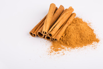 Cinnamon sticks and powder on white background