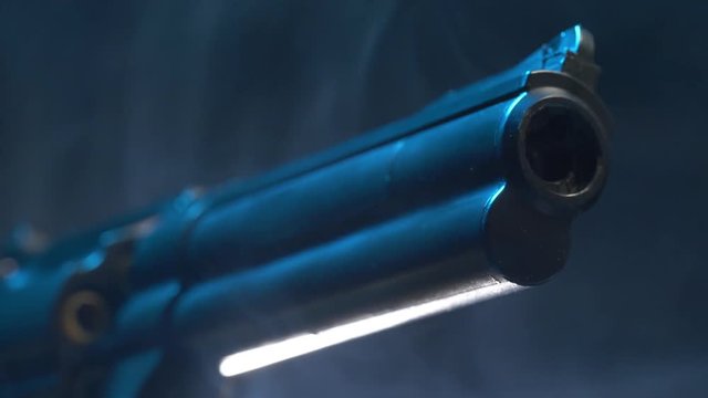 Camera making a closeup shot on the barrel of a revolver pistol gun.