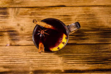Cup of mulled wine with cinnamon on wooden table. Top view