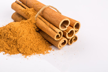 Cinnamon sticks and powder on white background