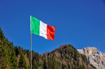 Italian flag, background with mountains and blue sky