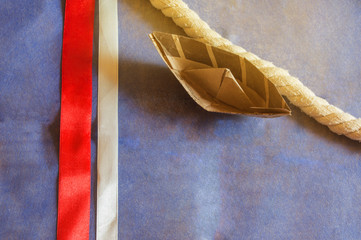 USA holiday, Happy Columbus Day paper boat on blue background and ribbon decoration, SOLAR LIGHT