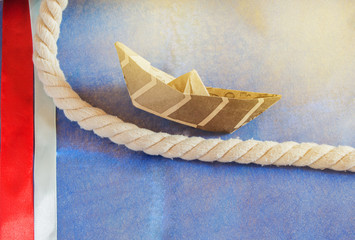 USA holiday, Happy Columbus Day paper boat on blue background and ribbon decoration, SOLAR LIGHT