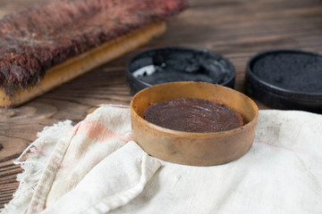 brushes and cream for cleaning and polishing shoes on a wooden table