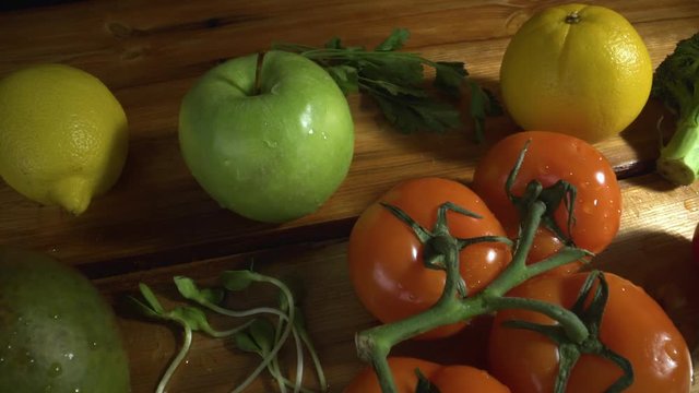 Vegetables on wood. Apple, lemon, mango, sprouted sunflower seeds, tomatoes, broccoli, orange, parsley, pepper.
