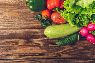 Fresh harvest ripe vegetables zucchini cucumber greens pepper laid out on a wooden background. Healthy food Harvesting.