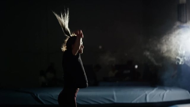 Young woman training in the gym for trampoline gymnastics and parcour