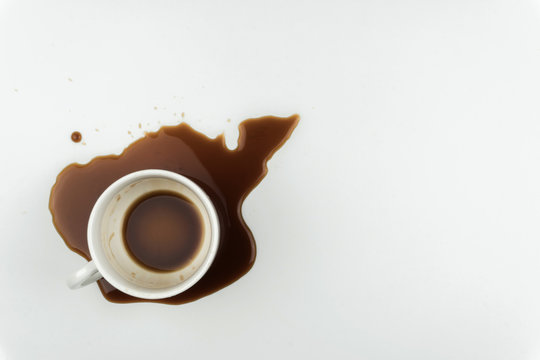 Top View Of A Cup Of Coffee And Spilled Coffee On The White Table