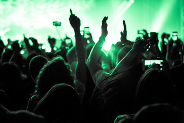 hands to the skies of people dancing and having fun at the live music concert