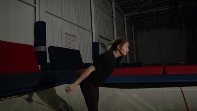 Young woman training in the gym for trampoline gymnastics and parcour