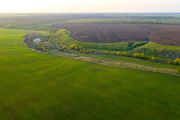 Spring fields, meadows, ravines at sunset from the quadrocopter