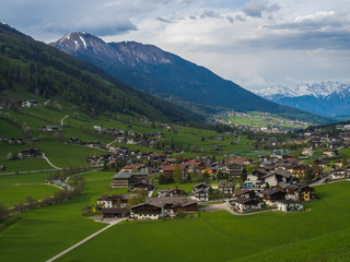 Fototapeta na wymiar Spring mountain rural landscape. View over Stubaital Stubai Valley near Innsbruck, Austria with village Neder, green meadow, snow covered alpen mountain peaks