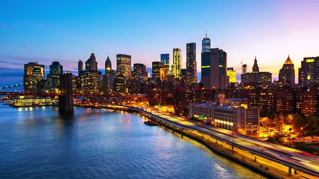 New York, USA. Aerial view on the city skyline in New York City, USA during the sunset. Famous skyscrapers of the concrete jungle and car traffic. Time-lapse of Brooklyn Bridge, zoom out