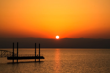 Fototapeta na wymiar Sun rises over mountains alongside the Sea of Galilee