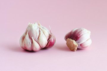 Fresh garlic on a light pink background