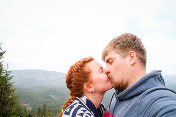 Couple of lovers guy and girl in the mountains kiss and hug. Traveling couple. Love in the Carpathians