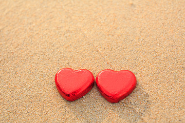 Fototapeta premium Chocolate color Lovely red heart on the beach. Background is a natural in real place, creative Valentine's Day Concept, tropical style background made in Phuket, Thailand.
