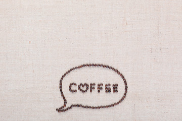 Coffee letters in talk cloud from coffee beans on linen canvas arranged bottom center.