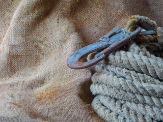 Vintage still life. Old carbine and rope against the background of burlap.