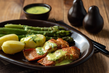 Roasted salmon with boiled potatoes and asparagus in creamy dill sauce.