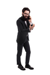 Naklejka premium Full length portrait of a aggressive bearded businessman swears on the smartphone, isolated on white background