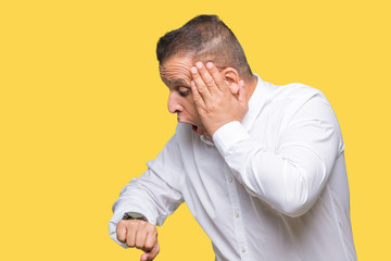 Middle age arab elegant man over isolated background Looking at the watch time worried, afraid of...