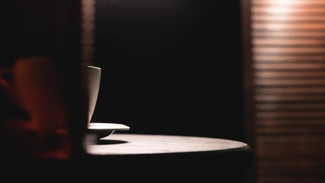 Hot coffee with stem goes up in slow motion. Wooden table with wooden background. Slider shot.