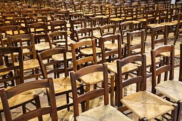 Sillas de madera y enea preparadas para un evento.