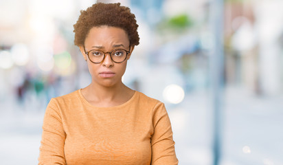 Obraz premium Młoda piękna African American kobieta w okularach na białym tle sceptyczny i nerwowy, marszczy brwi zdenerwowany z powodu problemu. Osoba negatywna.