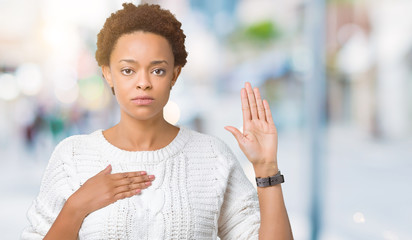 Beautiful young african american woman wearing sweater over isolated background Swearing with hand on chest and open palm, making a loyalty promise oath