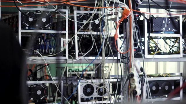 Mining farm for cryptocurrency, electronic devices with wires and cables. Stock footage. Mining bitcoins and cryptocurrency.
