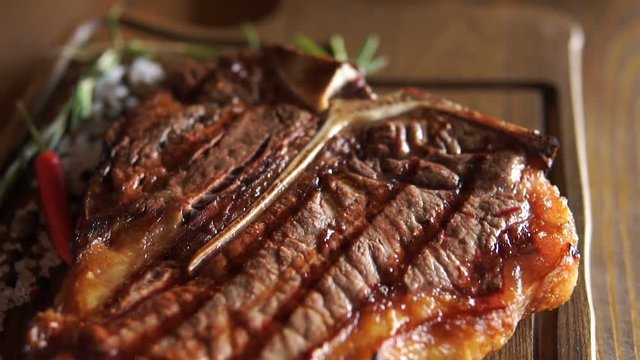 Hot juicy t-bone steak is served at the restaurant on a cutting Board
