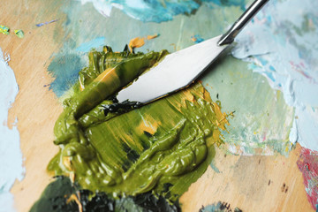 Blending with a palette knife of green paint on the palette