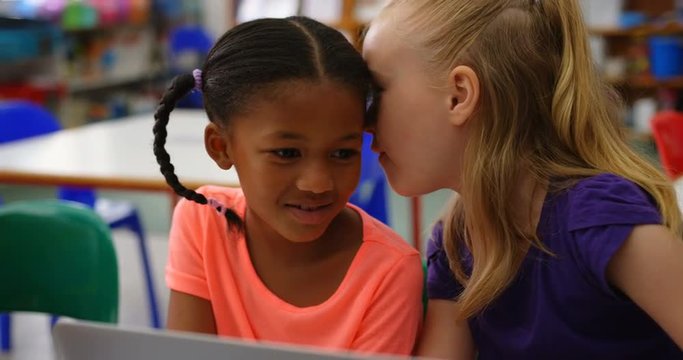 Front view of Mixed-race schoolgirls studying on laptop in the classroom 4k