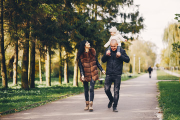 Fototapeta premium Cute family walking in a autumn park. Mother with little daughter