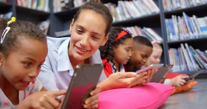 Front view of Caucasian female teacher and school kids studying on digital tablet in the schoo 4k